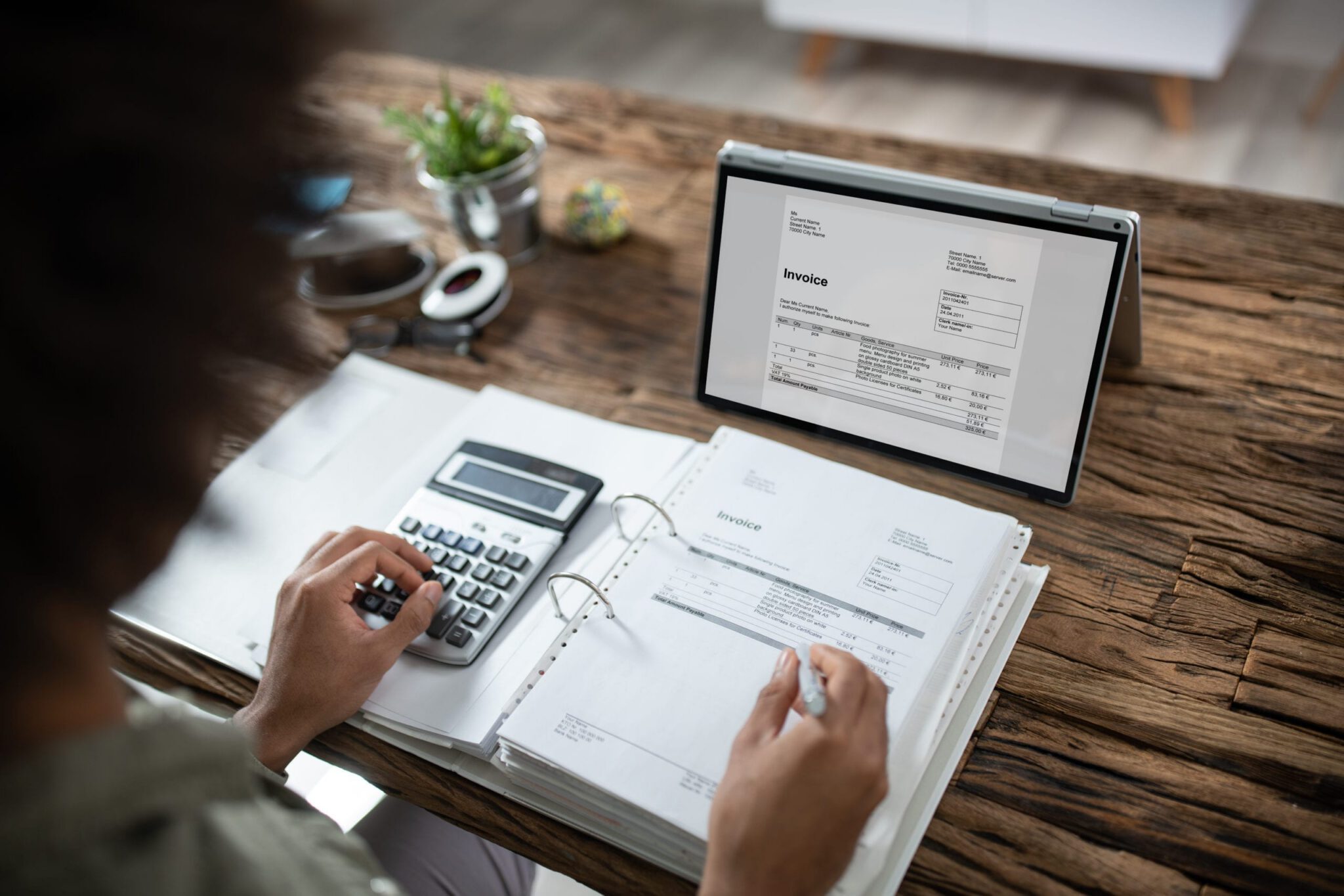 Travel agent managing money via book and computer