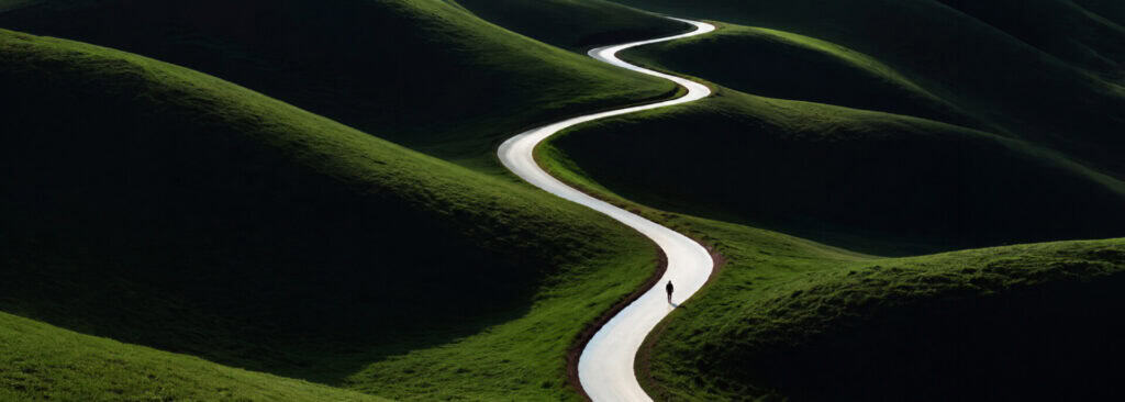A lone person walks along a bright winding path through rolling green hills under dramatic light and shadow.